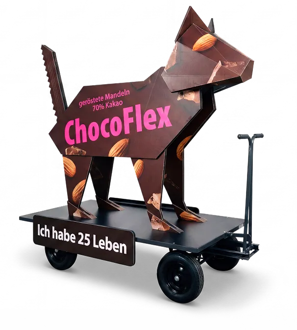 Cardboard cat on a cart as a promotional figure for ChocoFlex chocolate with roasted almonds and the slogan "I have 25 lives"
