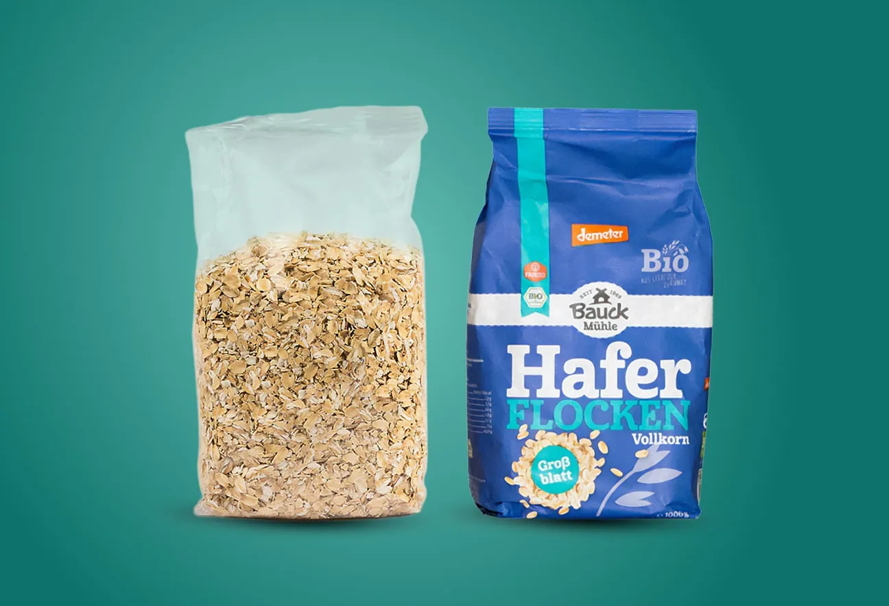 Clear oat flakes bag and blue wholegrain oat flakes package placed side by side against a green background layout view